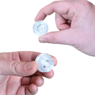 Adaptateur Vision pour Pod Flowtoys : deux pièces rondes en plastique translucide blanc avec axe central, montrées en gros plan entre les doigts.