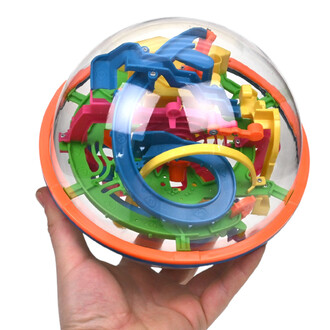 Addict A Ball, balle puzzle transparente remplie de pièces colorées et de rails internes, tenue par une main.