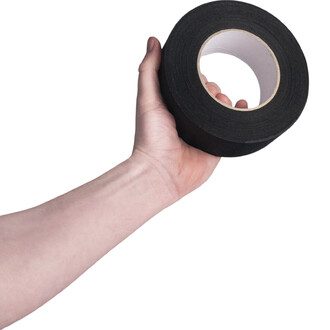 Rouleau d'adhésif aérien noir de 5 cm de large, tenu dans une main. Le rouleau est de couleur noire et présente un mandrin central en carton.