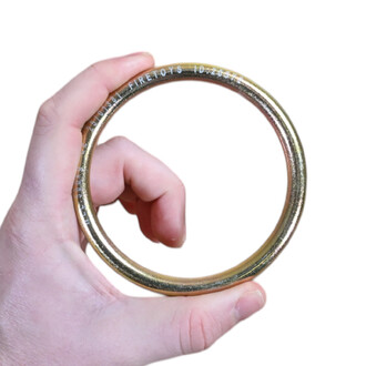 Gros plan d'un anneau rond en acier galvanisé tenu par une main, accessoire pour hamac aérien.