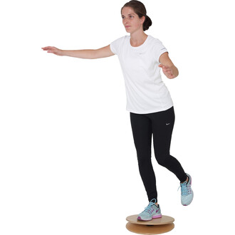 Personne en équilibre sur une plateforme de jonglerie, vêtue d'un t-shirt blanc et de leggings noirs, les bras tendus pour maintenir sa posture. Elle porte des chaussures de sport bleu clair avec des accents de violet.