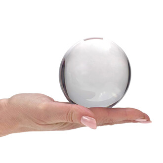 Balle acrylique transparente tenue entre le pouce et l'index d'une main sur fond blanc