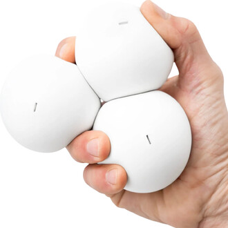 Trois balles BBX Beanbag blanches tenues ensemble dans une main, avec une légère surface texturée et une fente sur chaque balle.