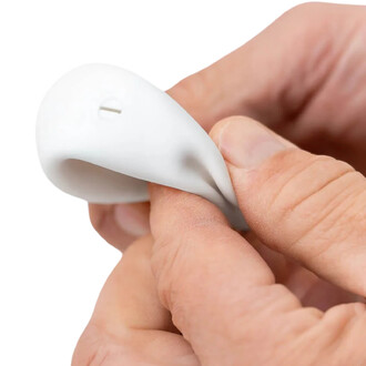 Balle BBX Beanbag de Play, montrant un gros plan d'une main tenant la balle en matériau souple, légèrement pliée, mettant en évidence un petit trou sur la surface de la balle.