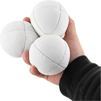 Una mano che regge tre palline da giocoleria Orbit Prototype bianche, realizzate in tessuto morbido, con cuciture a vista che ne formano i segmenti.