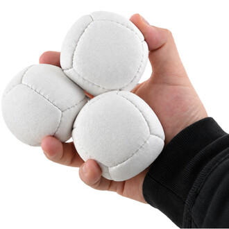 Una mano tiene in una sola tre palline da giocoleria Orbit in pelle scamosciata bianca, mostrandone le cuciture e la trama.