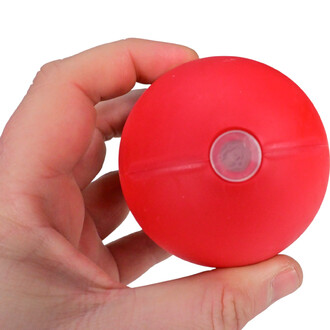 Boule jonglerie rouge de 80 mm, tenue dans une main, avec un petit trou central.