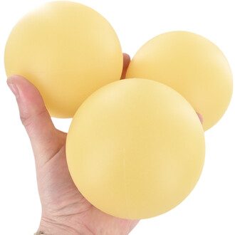 Trois balles de jonglage Éozoé phosphorescentes, diamètre 100 mm, couleur jaune clair, tenues dans une main.