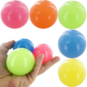 Balle rebond phosphorescente de couleur variée, y compris rose, orange, vert, bleu et jaune. Un main tient plusieurs balles, tandis que d'autres balles sont visibles à côté. Les balles sont brillantes et conçues pour rebondir.