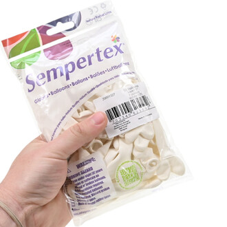 Sachet de ballons cœur blancs Sempertex, 6 pouces, emballés dans un sachet transparent; une main tient le paquet, étiquette et code-barres visibles.
