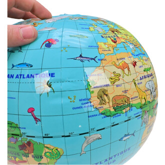 Ballon globe de 30 cm représentant les continents avec des illustrations d'animaux marins et terrestres, tenu par une main sur la surface bleue du globe.