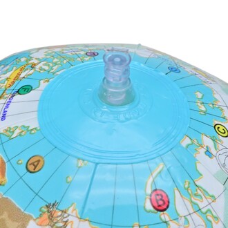 Ballon globe représentant une carte du monde, avec une valve bleue sur le dessus pour le gonflage, détails colorés des continents et des océans visibles.