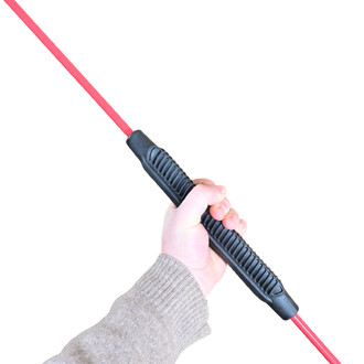 Main tenant une barre flexible avec une partie colorée en rouge et une prise en main noire. L'image met en évidence le design ergonomique et la texture de la poignée.