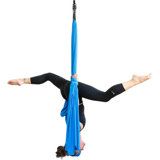 Femme suspendue tête en bas dans un tissu aérien bleu fixé à une barre de répartition, jambes écartées en grand écart, portant une tenue de sport noire.