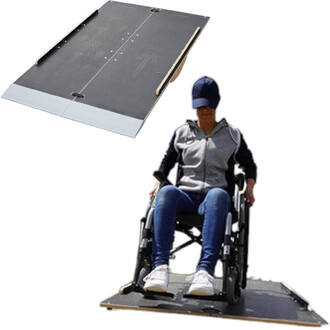 Plateforme de mobilité avec une personne en fauteuil roulant utilisant la rampe pour accéder à une surface. La rampe est noire avec des flèches indiquant la direction, équipée de supports latéraux.