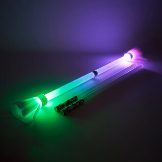 Bâtons de diabolo lumineux de couleur verte et violette, avec des pointes éclairées. Le produit inclut deux bâtons supplémentaires avec un design en noir et blanc. Le fond est sombre, mettant en valeur les lumières des bâtons.