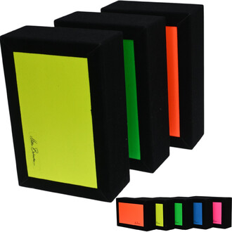 Boîte à cigares Fluo MB composée de plusieurs modèles avec des couvercles de couleurs fluorescentes (jaune, vert, orange et rose) sur un fond noir. Les boîtes ont des contours carrés et un design élégant.