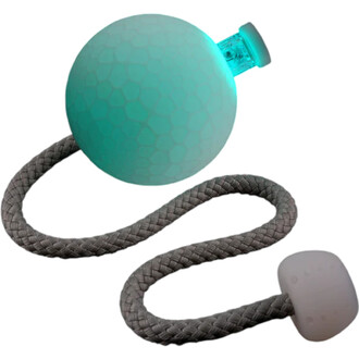 Bolas Coral Flowtoys avec une boule en silicone translucide d'une teinte turquoise, dotée d'un motif hexagonal et d'un embout lumineux. La boule est attachée à une corde tressée grise, se terminant par une poignée en silicone blanche.
