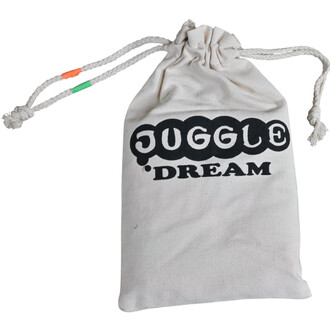 Sac blanc en coton avec cordons de serrage et logo noir « JUGGLE DREAM »; extrémités des cordons en orange et vert, destiné au rangement des bolas de jonglerie.