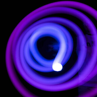 Bolas LED Echo Orbit 20 fonctions, corde lumineuse violette et bleue enroulée en spirale sur fond noir.