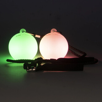 Bolas LED Echo Orbit - Firetoys : deux bolas lumineuses, l'une verte et l'autre rose, avec des cordes de manipulation noires, sur un fond sombre.