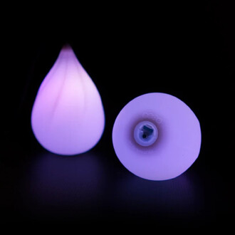 Bolas lumineuses de forme stylisée, émettant une douce lumière violette, positionnées sur un fond noir, montrant deux angles : l'une en forme de goutte et l'autre de forme ronde, avec un éclairage mettant en valeur leur design.