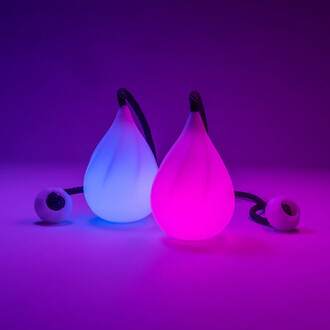 Bolas lumineuses de couleur bleue et rose, en forme de goutte, avec une corde noire, sur fond violet.