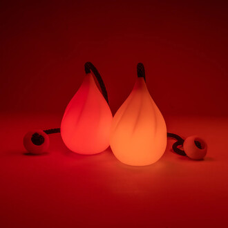 Bolas lumineuses Lumi Pro de ThreeWorlds, deux éléments en forme de goutte avec éclairage LED, accompagnés de cordes. Présentées sur un fond rouge.