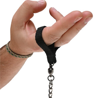 Main tenant une boule de jonglage avec un cordon noir et une attache métallique, montrant une prise de jonglage. Une bracelet multicolore est visible au poignet.