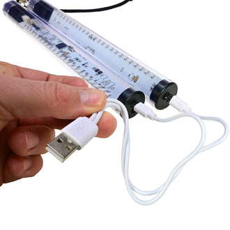 Main tenant un câble USB blanc, se connectant aux LED des Pixel Poi Juggle Dream, qui sont transparents avec une bordure noire.