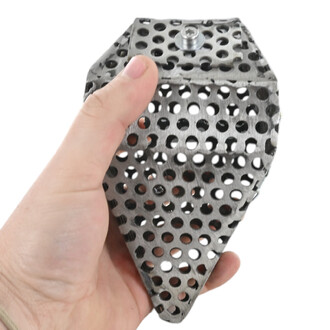 Main tenant un bloc métallique perforé en forme de prisme avec de nombreux trous circulaires, sur fond blanc.