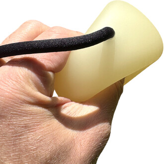 Main tenant une boule lumineuse de contact avec un cordon noir, sur fond blanc. La boule est de couleur claire et translucide, présentant une surface lisse.