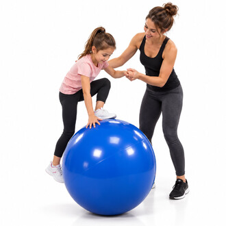 Una grande palla blu per l'equilibrio, di 70 cm di diametro, viene usata da una bambina per arrampicarsi, aiutata da un adulto che le tiene la mano, su sfondo bianco.