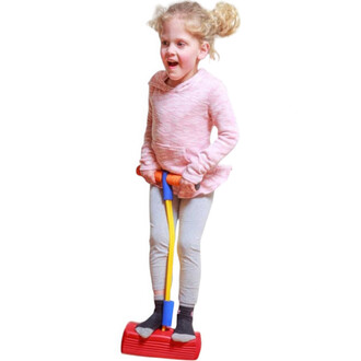 Une petite fille souriante se tient sur un Bungee Sauteur. Elle porte un pull rose clair et un pantalon gris. Ses cheveux sont attachés en deux petites couettes. Elle tient les poignées orange et bleue du sauteur, prête à s'amuser. Le sauteur lui-même est