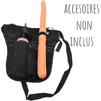 Ceinture tablier noire avec poche et sangles, fixant verticalement un long gode orange, accessoires colorés rose et vert visibles.