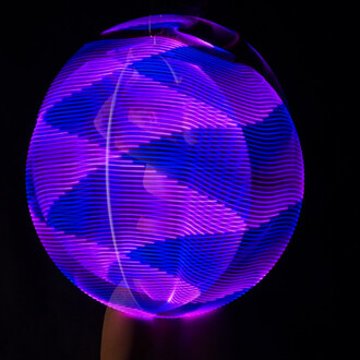 Effet lumineux violet et bleu en spirale autour d'un cerceau aérien, créant une illusion de mouvement.