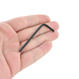 Clé Allen Dragon noire en L, petit outil hexagonal tenu entre le pouce et l’index, gros plan.