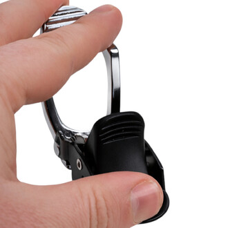 Gros plan sur une main manipulant un petit mousqueton métallique argenté avec mécanisme noir, montrant l’ouverture du clip.