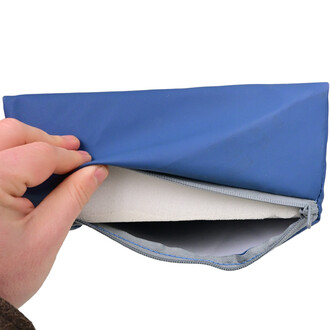 Coussin pour maintien de la nuque en bleu, avec une main tenant le côté zippé, révélant l'intérieur en mousse blanche.