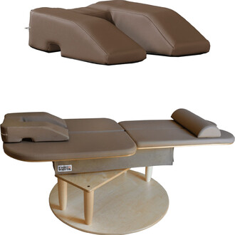 Matelas de massage en deux parties, recouvert de simili cuir marron, avec un repose-tête intégré et une conception ergonomique pour le confort des utilisateurs. La partie inférieure présente une base circulaire en bois, tandis que la surface supérieure es