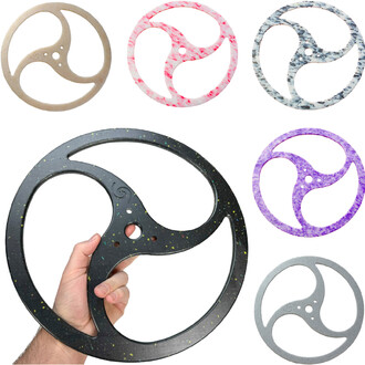 Disques Tri-Ying variés : un disque noir avec des paillettes, tenu par une main, entouré de disques rose marbré, bleu marbré, violet, gris, et beige sur un fond blanc.