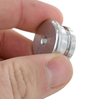 Embout fixe Fusion 22 mm sans joint — disque métallique argenté avec trou central, tenu entre des doigts.