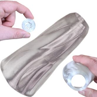 Gros plan d’un embout pour Pod Flowtoys avec adaptateur Vision : petit disque métallique argenté et adaptateur translucide en forme d’anneau, tenus entre les doigts.