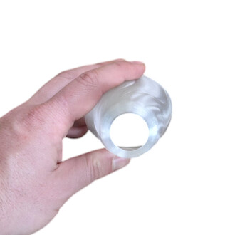 Embout translucide en silicone pour Pod Flowtoys, tenu entre le pouce et l’index, montrant l’ouverture circulaire.