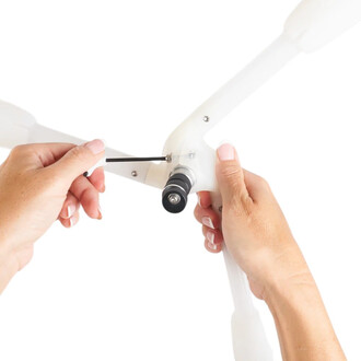 Détail d’assemblage: embout quick-release Dragon Threeworlds fixé sur une structure blanche, une main tient l’embout et l’autre serre la vis avec une clé Allen.