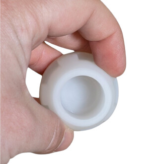 Gros plan sur un embout silicone Fusion blanc tenu entre le pouce et l’index, montrant l’ouverture centrale.