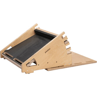 Support de jonglerie en bois, incliné, avec une surface noire texturée pour la pratique. Le design est moderne, avec des bords découpés et le logo pedalo gravé sur le côté.