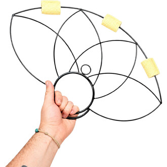 Eventails Fleur de Lotus : structure noire en cercles métalliques interconnectés formant un motif lotus, avec des coussinets jaunes en tissu et tenu par une main.