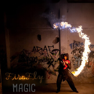 Une personne vêtue de noir avec un haut rouge réalise une performance de jonglerie de feu, utilisant un dispositif qui projette des flammes en forme de courbe lumineuse dans un environnement sombre et légèrement graffitié.