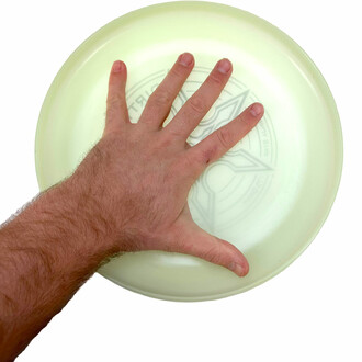 main posée dans un frisbee pour donner une idée de l'échelle et la taille du frisbee